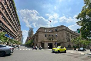 a yellow taxi cab in front of a building at Pine & Cedar Suites – Hua Xiao Ye in Shanghai
