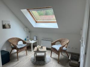 a living room with two chairs and a table at Les Chambres de Pascaline in Arrest