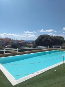 a large blue swimming pool on top of a building at Residence Le Terrazze in La Maddalena