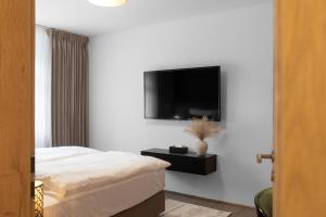 a bedroom with a bed and a tv on a wall at Hotel Ráztoka in Trojanovice