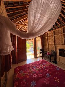 a bedroom with a large red rug in a room at Melody Surf Ekas Lombok in Ekas