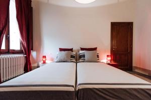 a bedroom with a large white bed with two lamps at Residenza Cavour in Empoli
