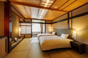 a bedroom with two beds and a couch in it at ホテルグランリゾート蓼科 in Chino +57 photos