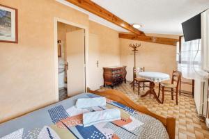 a bedroom with a bed and a desk and a table at Chambres D'hôtes Des 17 Clochers - in Saint-Vérand