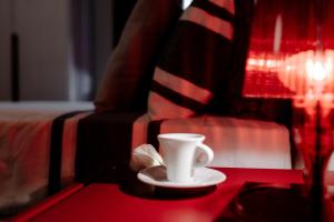 a coffee cup sitting on a table next to a bed at Residenza Cavour in Empoli