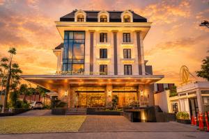 a large white building with a sunset in the background at Arkadewi Boutique Hotel Prawirotaman in Yogyakarta