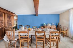 a dining room with a table with chairs and a blue wall at Chambres D'hôtes Des 17 Clochers - in Saint-Vérand