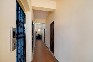 a hallway with white walls and a hallway with blue glass doors at Super Hotel O Bharat Institute of Engineering Hyderabad Formerly Blue Petals in Hyderabad +21 photos