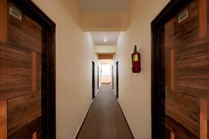 a corridor of a hallway with wooden doors at Super Hotel O Bharat Institute of Engineering Hyderabad Formerly Blue Petals in Hyderabad