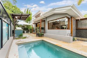 a swimming pool in front of a house at Noosaville duplex in Noosaville