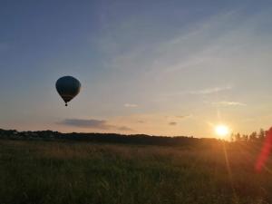 una mongolfiera che sorvola un campo al tramonto di Ferienwohnung Eifelglück a Utzerath