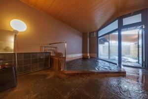 a large bathroom with a hot tub in a room at ホテルグランリゾート蓼科 in Chino