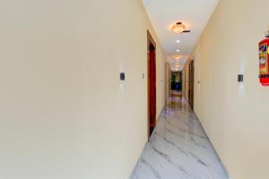 a hallway with white walls and a marble floor at Super Collection O MIDC Pimpari Pune Formerly SK Palace in Chinchwad