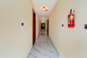 a hallway with a marble floor and a fire extinguisher at Super Collection O MIDC Pimpari Pune Formerly SK Palace in Chinchwad +23 photos
