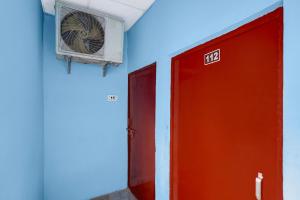 a room with a fan and a red door at Hotel O Singar Nagar Metro Station Lucknow Formerly Highway Inn in Alambagh +25 photos