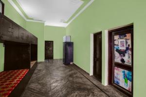 an empty room with green walls and a large painting on the wall at Hotel O Singar Nagar Metro Station Lucknow Formerly Highway Inn in Alambagh