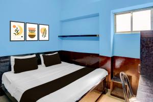 a bedroom with a bed with a blue wall at Hotel O Singar Nagar Metro Station Lucknow Formerly Highway Inn in Alambagh