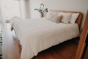 a bedroom with a bed with white sheets and a window at View Street Studios - Yarri in Albany