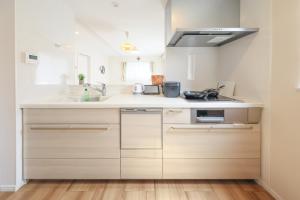 a white kitchen with a sink and a stove at 天空山 in Kawagoe