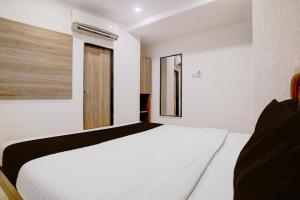 a bedroom with a white bed in a room at Collection O Crawford Market Formerly Al Ibrahim Hotel in Mumbai +22 photos