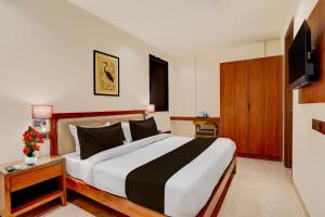 a bedroom with a large bed and a television at Townhouse Oak Sector 31 Noida in Noida