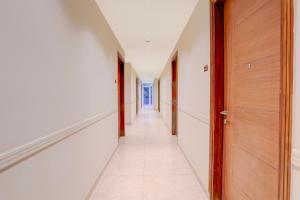 a corridor of a hallway with wooden doors at Townhouse Oak Sector 31 Noida in Noida