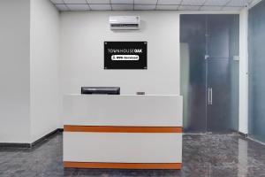 an office with a counter with a sign on the wall at Townhouse Oak Sector 31 Noida in Noida