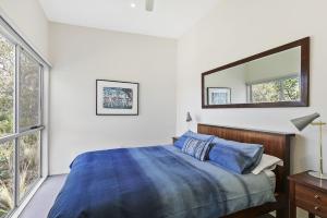 a bedroom with a bed and a mirror on the wall at Timbara Hideaway - Ocean Views - Pet Friendly in Moggs Creek