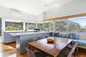 a kitchen and living room with a wooden table and chairs at Timbara Hideaway - Ocean Views - Pet Friendly in Moggs Creek