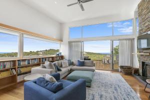 a living room with two couches and a fireplace at Timbara Hideaway - Ocean Views - Pet Friendly in Moggs Creek +8 photos