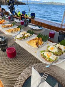a table with plates of food on a boat at Private Trip Labuan Bajo 2D1N in Labuan Bajo