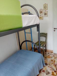 ジャッレにあるCasa Macchiaの二段ベッド2台と椅子が備わる客室です。