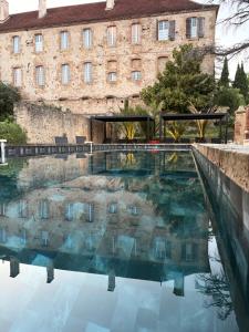 a pool of water in front of a building at Le Monastère de Saint Mont Hôtel & Spa in Saint-Mont