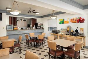 a restaurant with tables and chairs and a kitchen at Quality Inn & Suites Gallup I-40 Exit 20 in Gallup