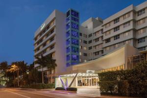 a large building with a fountain in front of it at Radisson Resort Miami Beach in Miami Beach