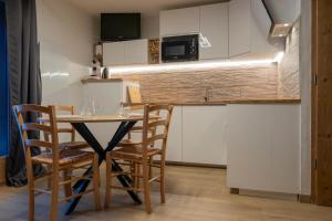 a small kitchen with a table and chairs in a room at TMB Tour du Mont-Blan in Les Contamines-Montjoie +13 photos