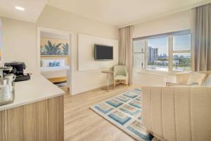 a hotel room with a bed and a living room at Radisson Resort Miami Beach in Miami Beach