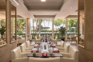 a restaurant with a long table and white chairs at Radisson Resort Miami Beach in Miami Beach