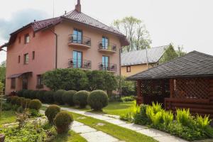 a large pink house with a garden in front of it at Sukhoviia in Yasinya