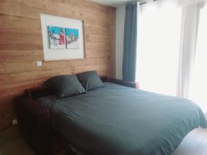 a bed in a bedroom with a wooden wall at TMB Tour du Mont-Blan in Les Contamines-Montjoie