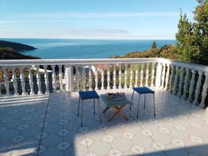 a balcony with two chairs and a table and the ocean at Apartmani Kruče in Ulcinj
