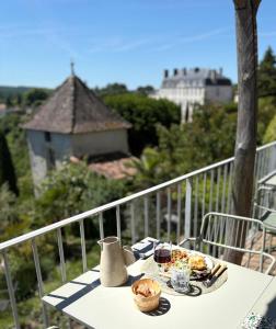 a table with a plate of food on a balcony at Hôtel Particulier Nontron - chambre d'hôtes et meublés de tourisme in Nontron