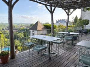 a patio with tables and chairs on a deck at Hôtel Particulier Nontron - chambre d'hôtes et meublés de tourisme in Nontron