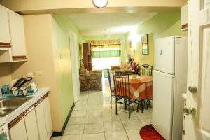 a kitchen and dining room with a table and a refrigerator at Angel's Apartment Jamaica in Kingston
