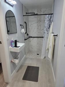a white bathroom with a shower and a sink at Cozy SeaTac home in SeaTac