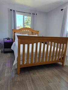 a wooden bed in a room with a window at Cozy SeaTac home in SeaTac