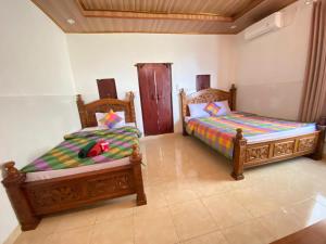 two beds sitting next to each other in a room at Kabera Bungalow Ubud in Ubud