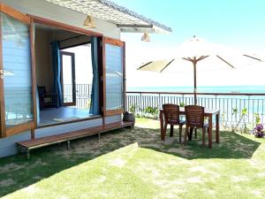 a patio with a table and chairs and an umbrella at Hidden Beach Bungalow Sea View in Hoi An