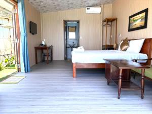 a bedroom with a bed and a desk and a table at Hidden Beach Bungalow Sea View in Hoi An