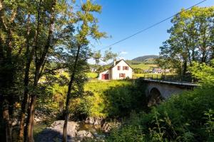 a bridge over a river with a house in the background at Chez lilles in Arette